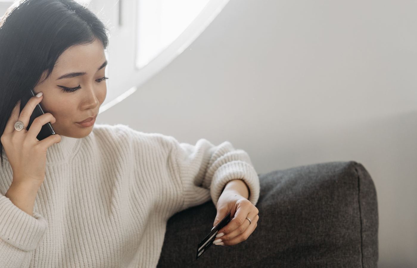 ลูกค้าถือบัตรเครดิตอยู่ในมือ ขณะคุยโทรศัพท์ถามทางร้าน